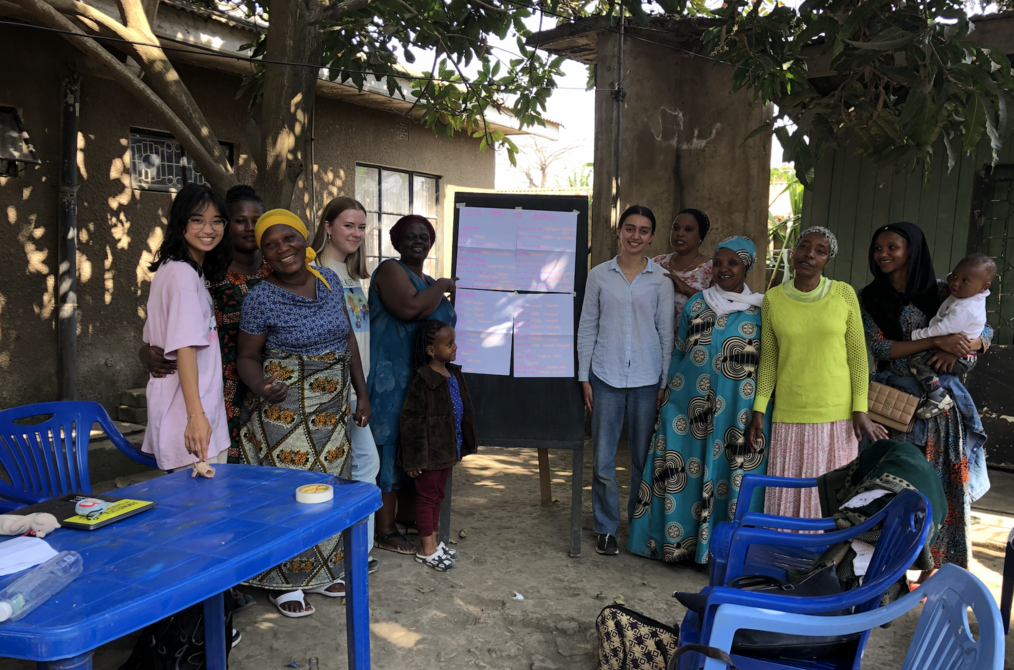 A group of women stand in front of a blackboard.