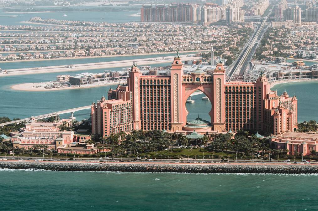 A birds eye view of a city in the UAE shows buildings along a shore.