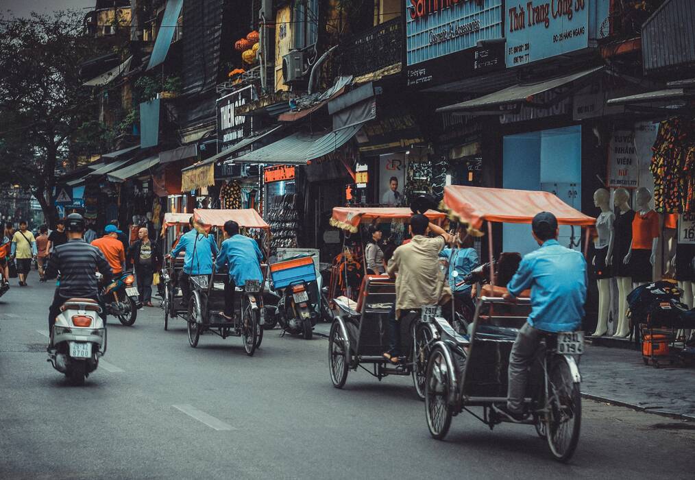 Pedicabs ride down a street in Vietnam.