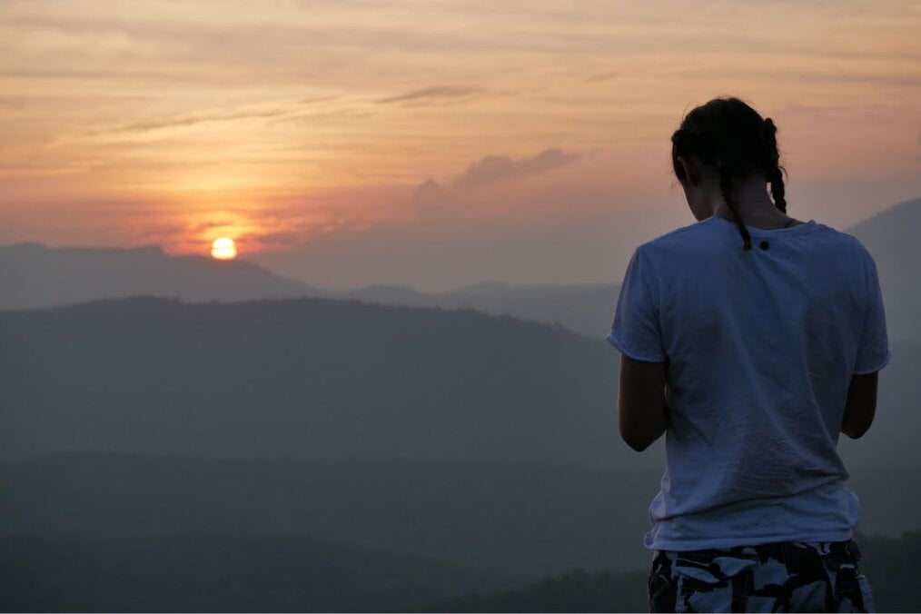Sunset over the horizon Traveler looking towards sunset over horizon