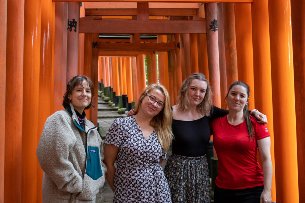 Students smiling under a shrine in Japan