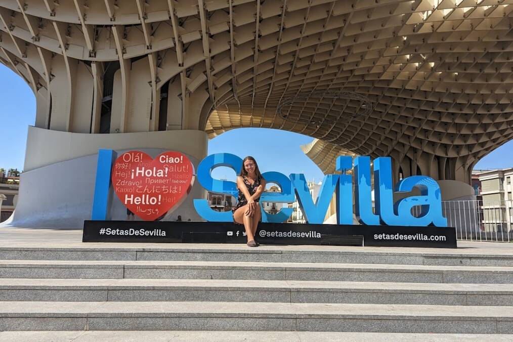 A student posing with a sign in Sevilla