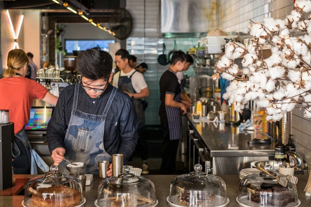 Photo by Daniel Norris on Unsplash A man works in a busy cafe.