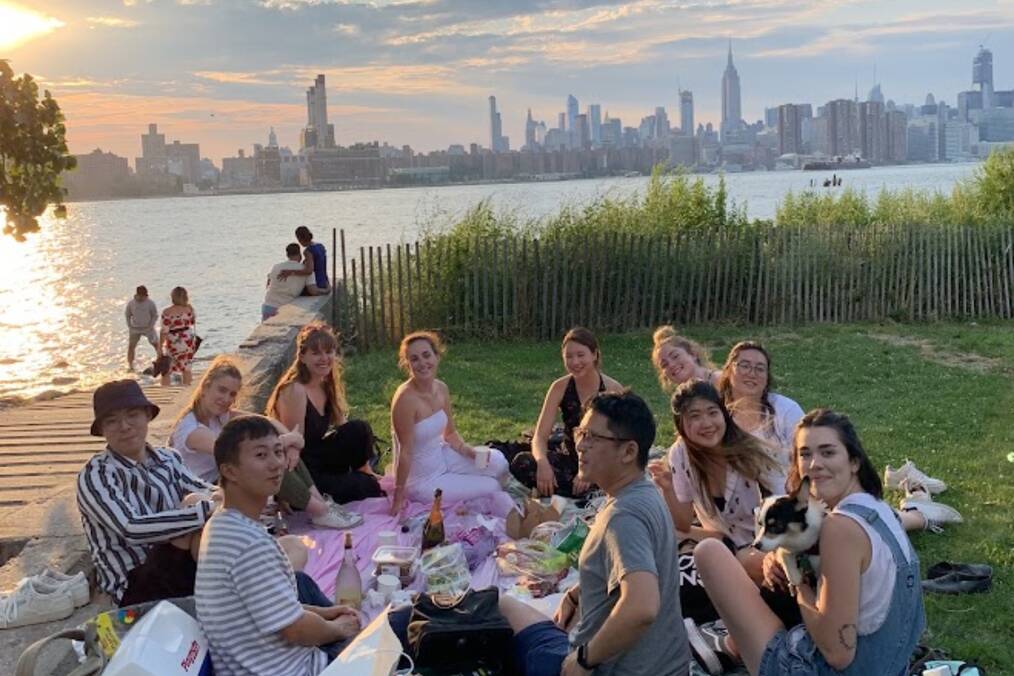 A group of interns sitting next to a river in the city 