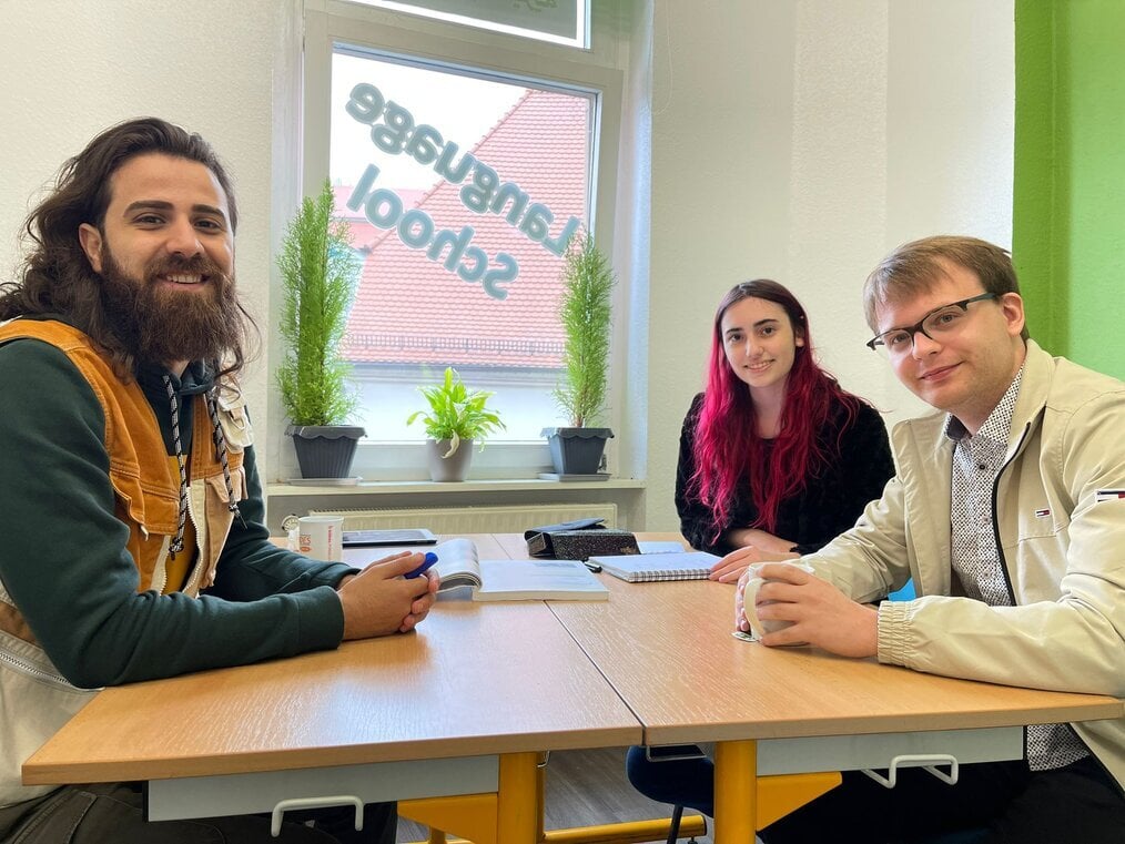 EC Germany Three people sit at a table.