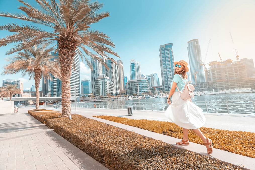 A woman poses with Dubai skyscrapers in the background.