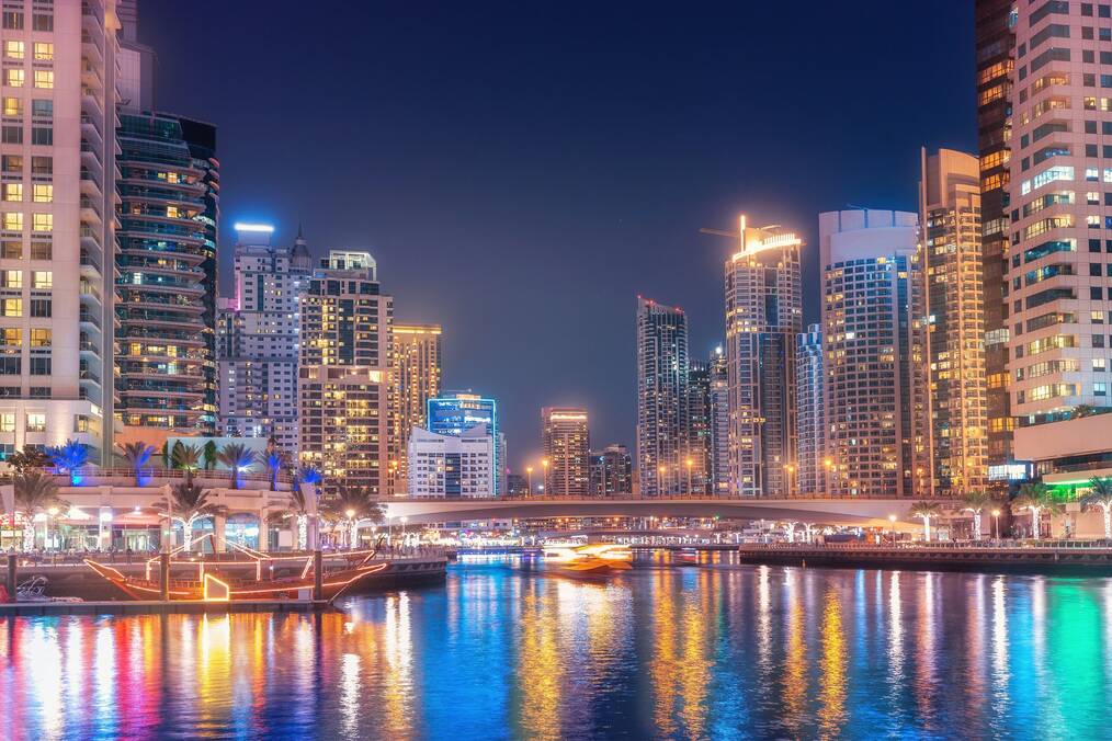 A view of Dubai at night on the water.