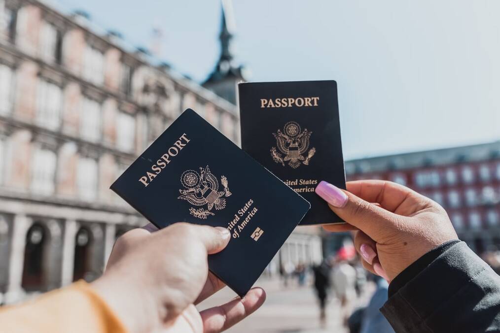 Two people holding their passports out 