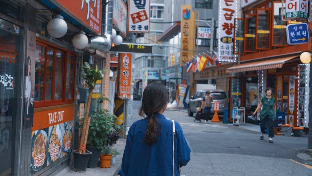 Photo by yongzheng xu on Unsplash A woman walks down a street in South Korea.