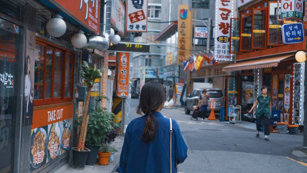 A woman walks down a street in South Korea.