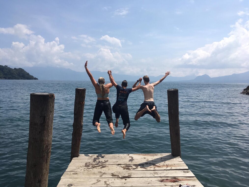 CDE Three tens jump in the air at the end of a dock.