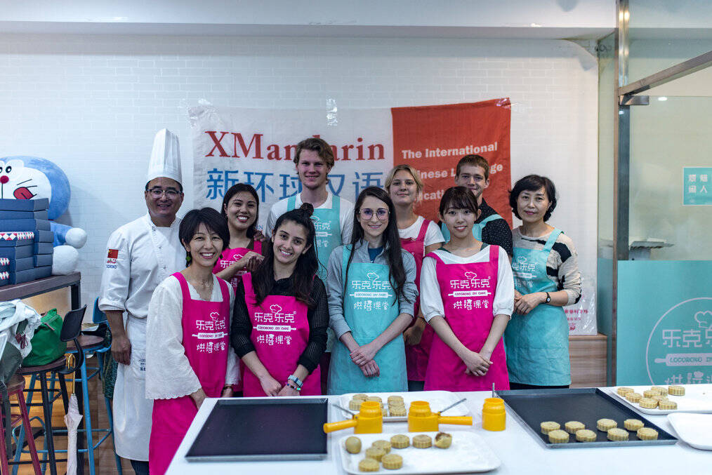 A group of people in aprons stand with a chef.
