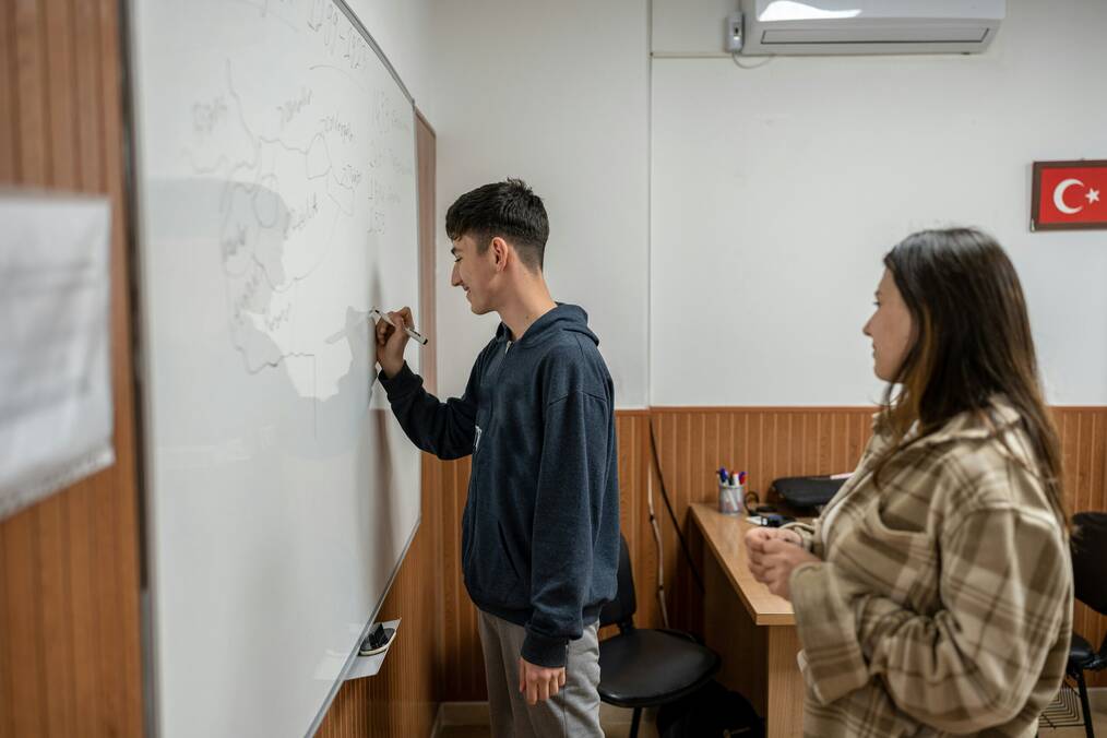 A student drawing on the whiteboard in the classroom
