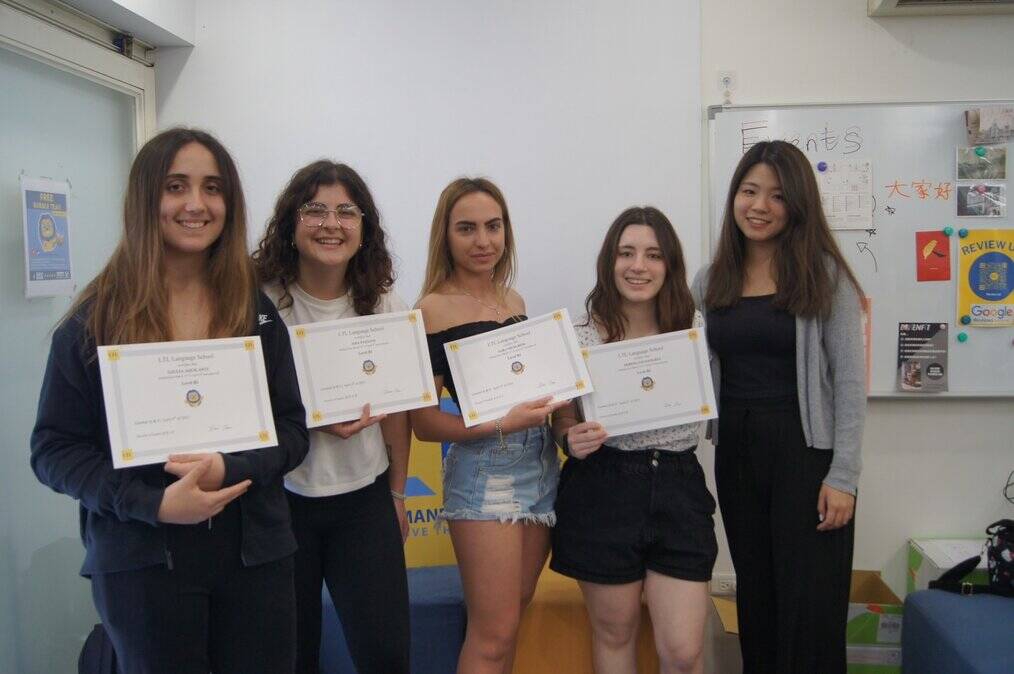 Four women stand smiling and holding certificates.