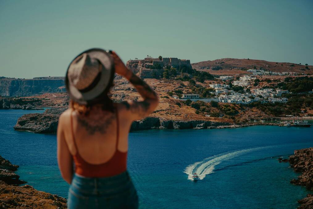 A woman looking towards Lindos village in Greece