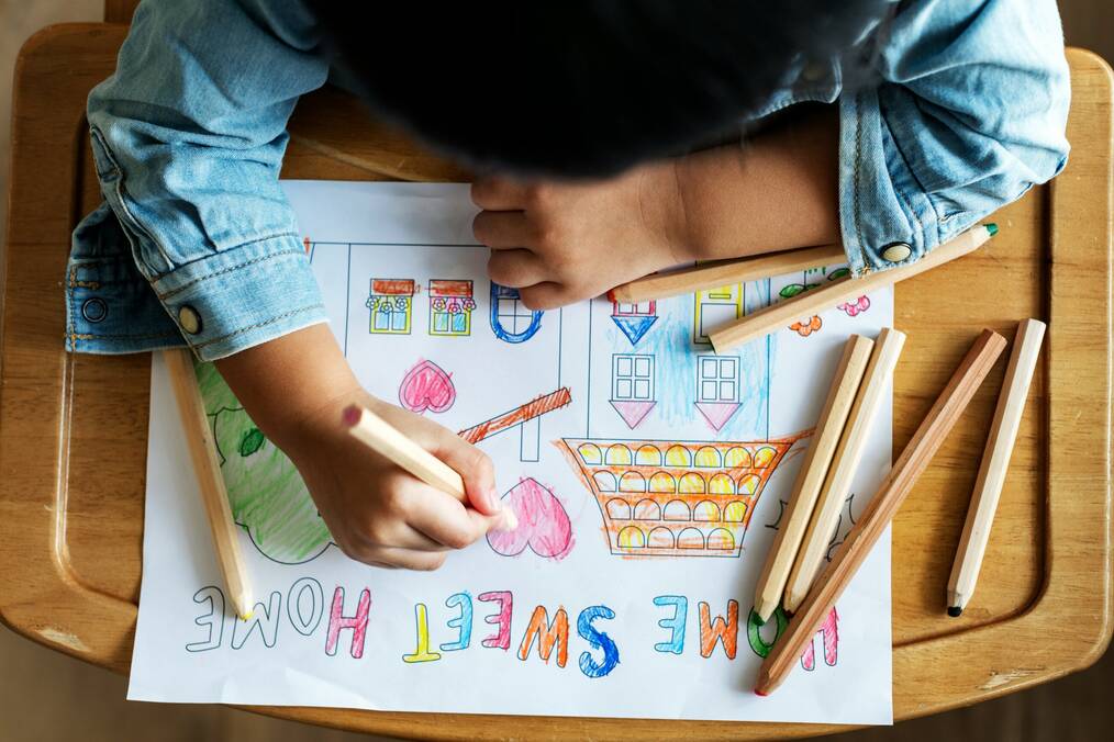 A child coloring a house.
