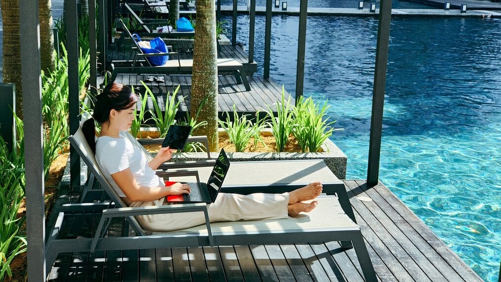 Photo by OPPO Find X5 Pro on Unsplash A woman works on a laptop beside a pool.