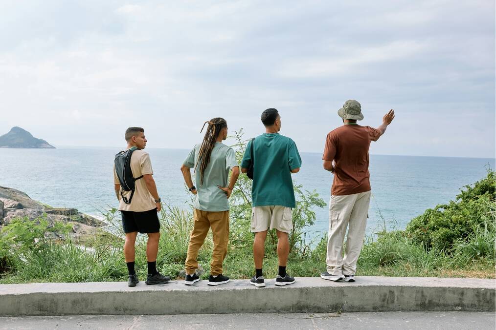 A tour guide and a group of travelers looking out towards sea