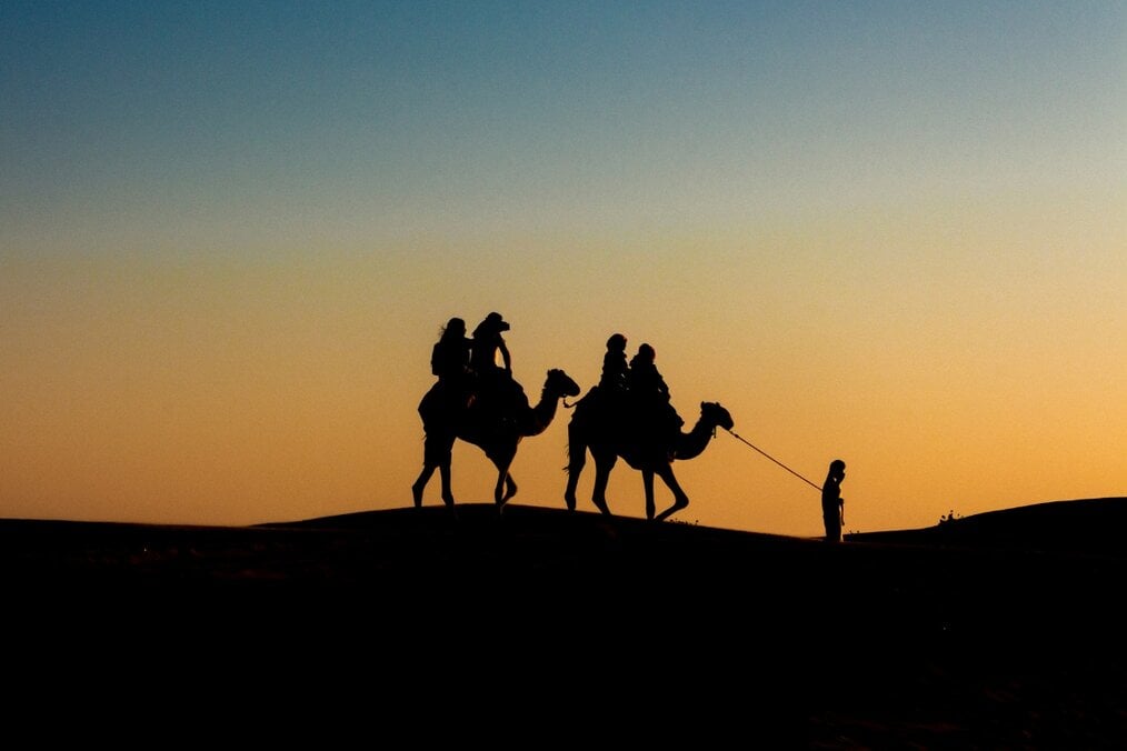 Tipping in the Middle East People riding camels in the destert