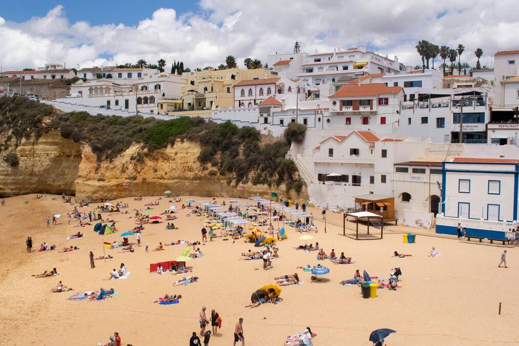 A beach in Portugal with buildings in the background.