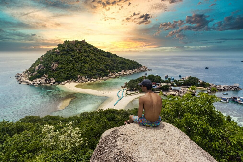 Photo by Darren Lawrence A man sits on a rock overlooking the ocean.