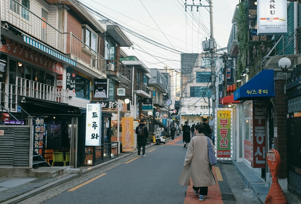 Photo by Huy Phan People walk down a shopping street in Seoul.