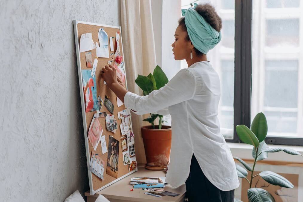 A woman decorates a bulletin board.