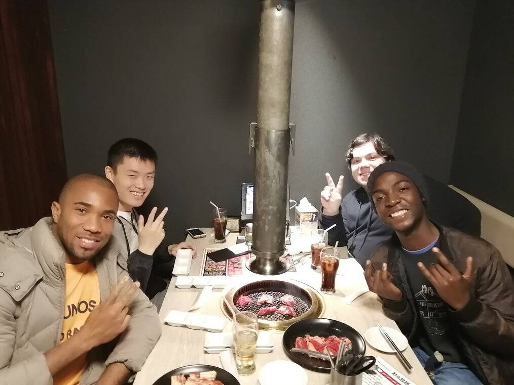 Four friends pose for a picture in a restaurant.