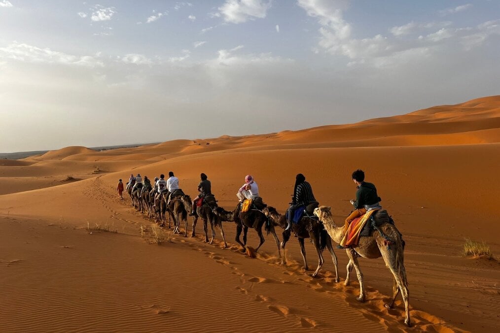 Maeve F, CIEE, Morocco, Study Abroad.jpeg A group of people going through the desert on camels
