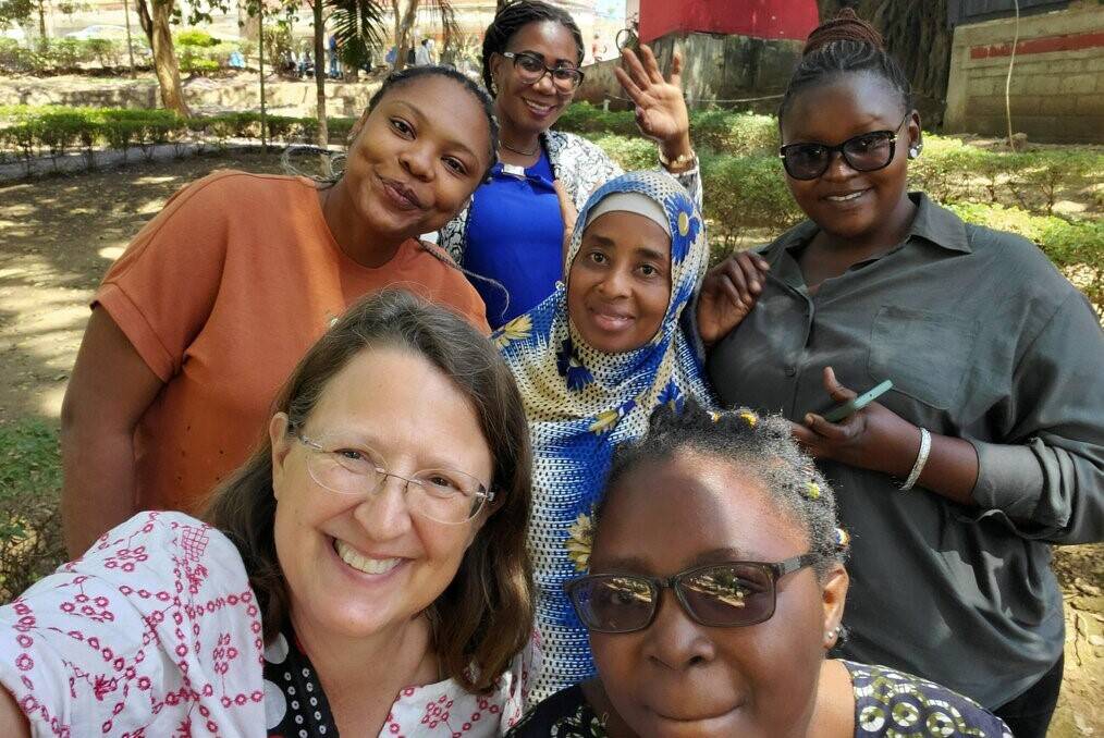Women smile for the camera and take a selfie.