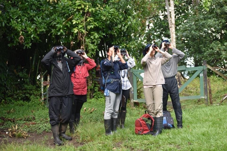 GVA A group of people look a something through binoculars.