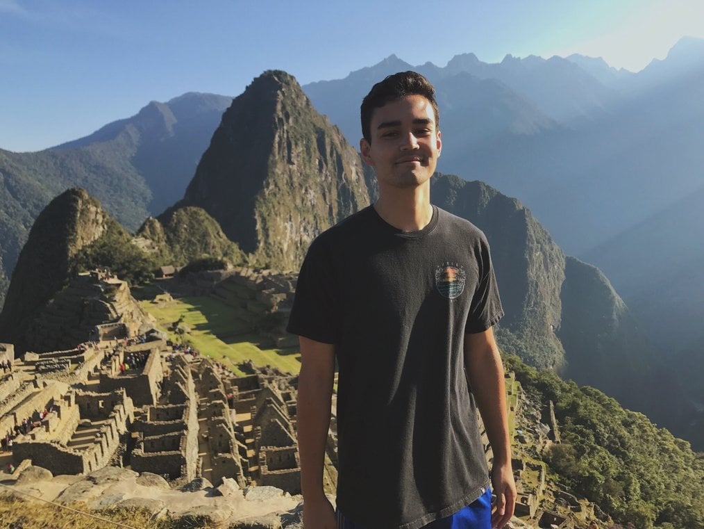 Peru A man stands and smiles with Machu Picchu in the background.