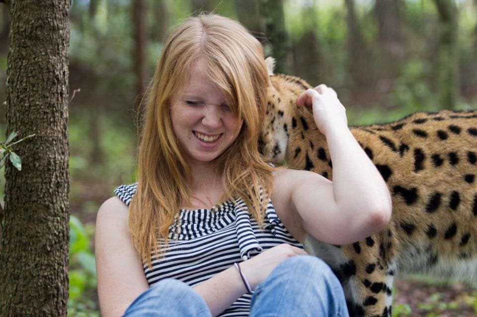 Twala A girl laughs as a leopard walks behind her.