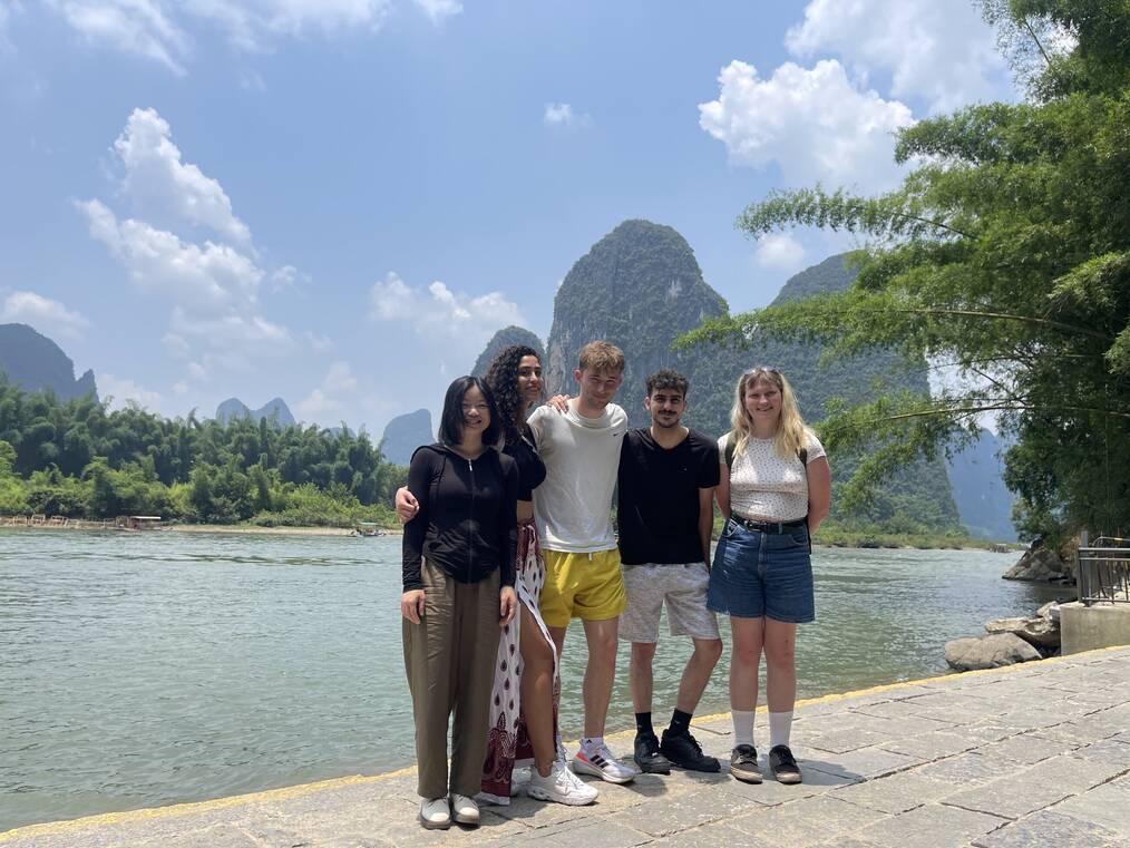 Students smiling in front of water and rocks