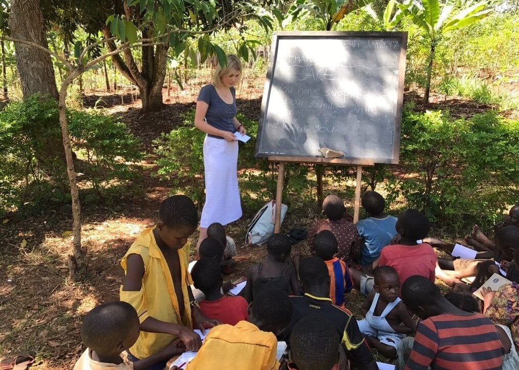 RU A woman teaches a group of children outside.