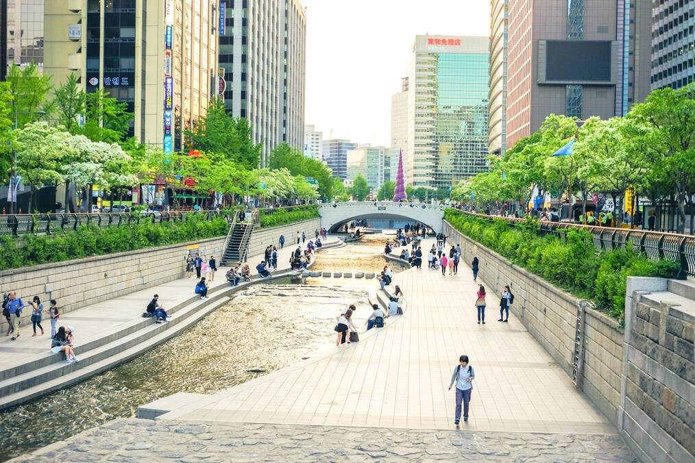 People sit and walk along a river in Seoul, Korea.