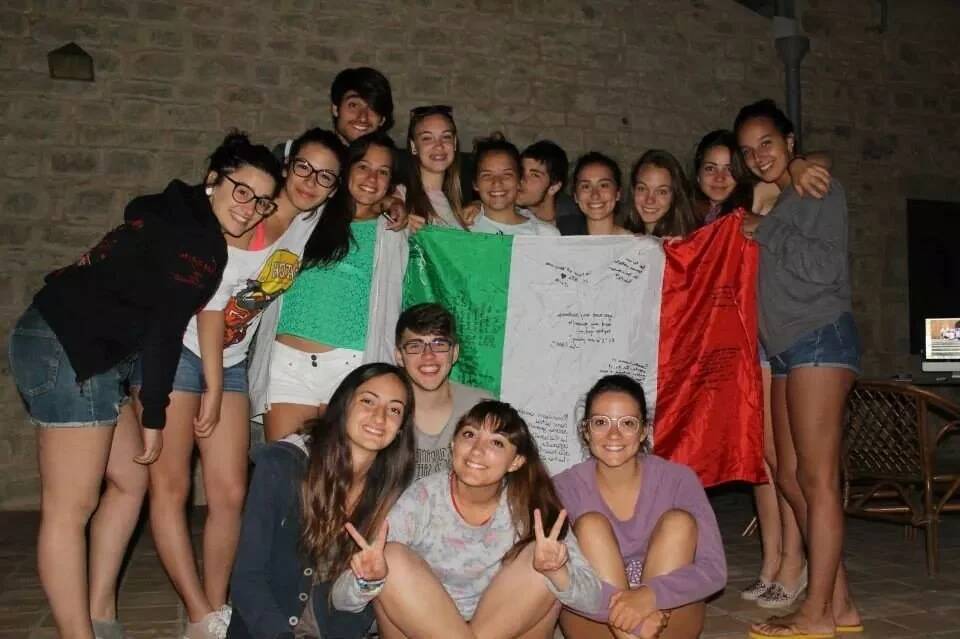A group of teens hold an Italian flag.