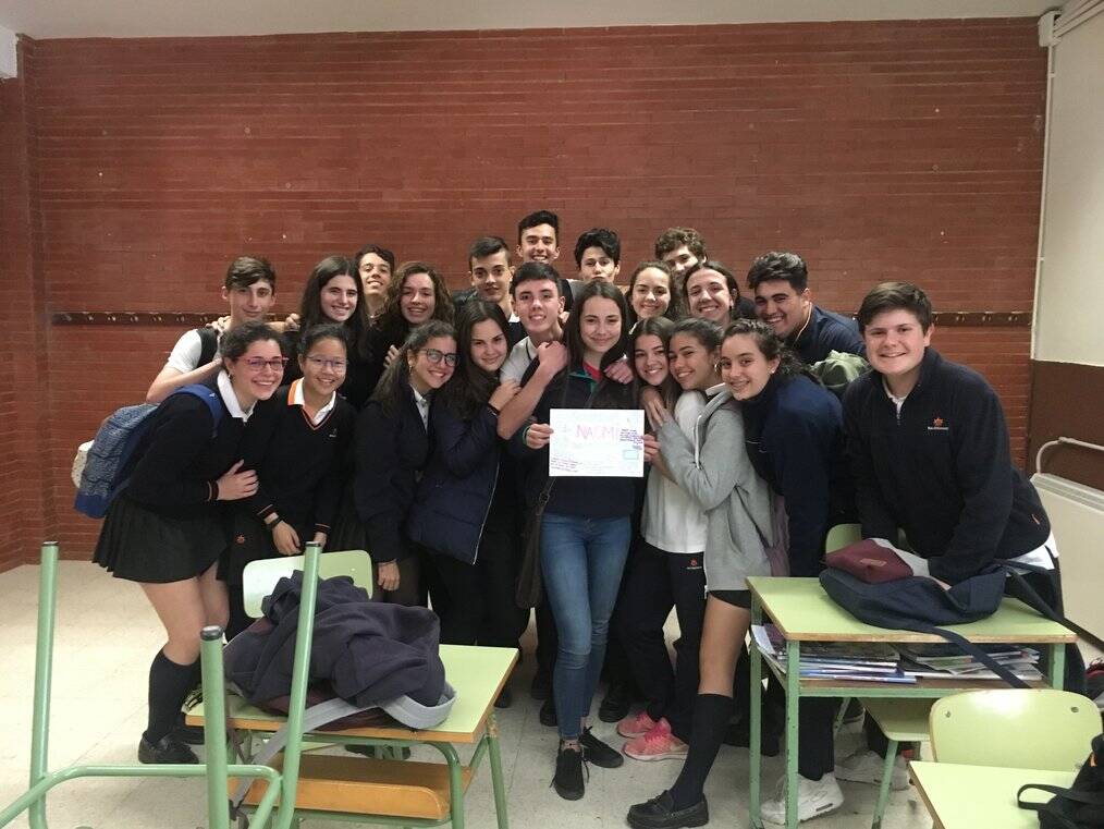 A group of high school students in Spain pose with their exchange student.