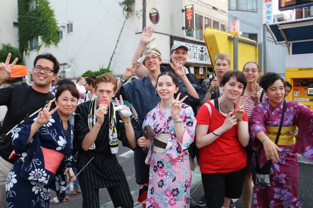 A group of students in traditional Japanese dress pose for a photo.