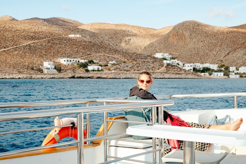 Volunteer sail crew member A person relaxing on a boat near the shoreline