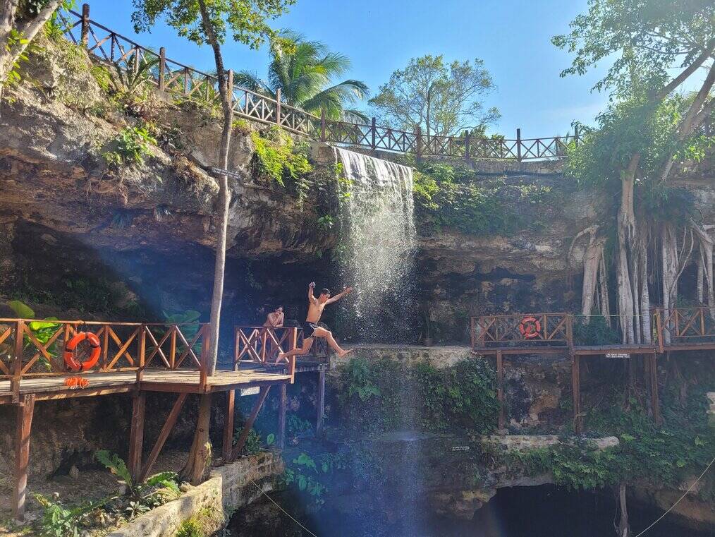 A man jumps off a platform into a body of water.