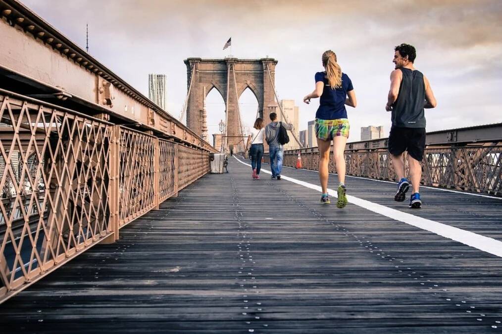 Two people jogging on a bridge 