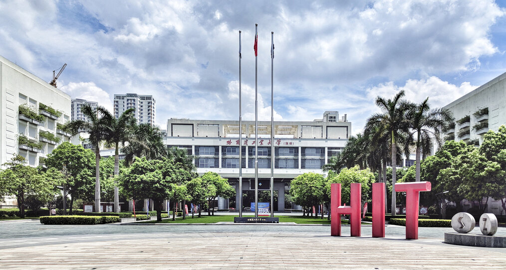 A large sign that says "HIT" sits in front of a building on a university campus.