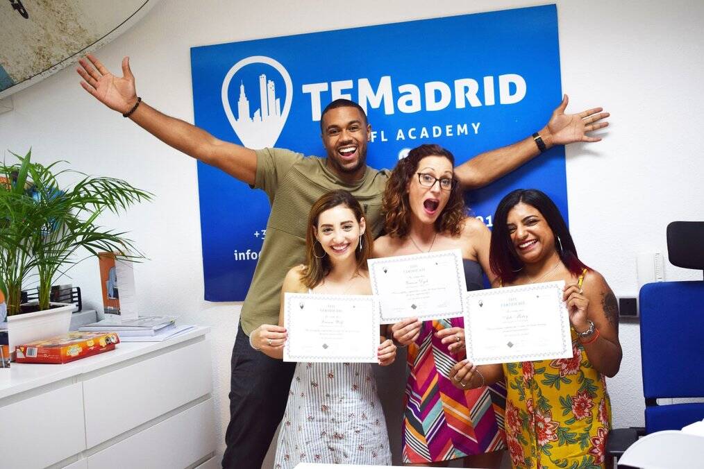 A group of people smile and hold TEFL certificates.