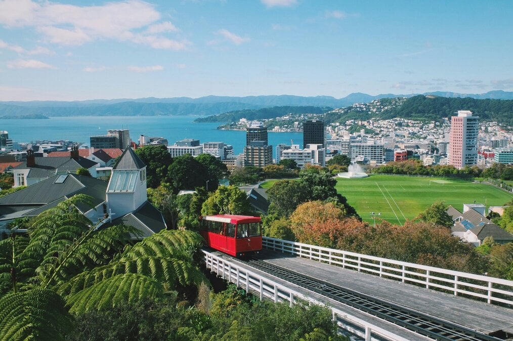 Photo by João Marcelo Martins on Unsplash A red tram drives up a hill with a harbor in the background.