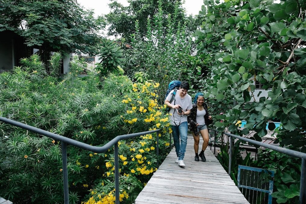 Digital nomad couple Two people walking through a forest while looking at their camera