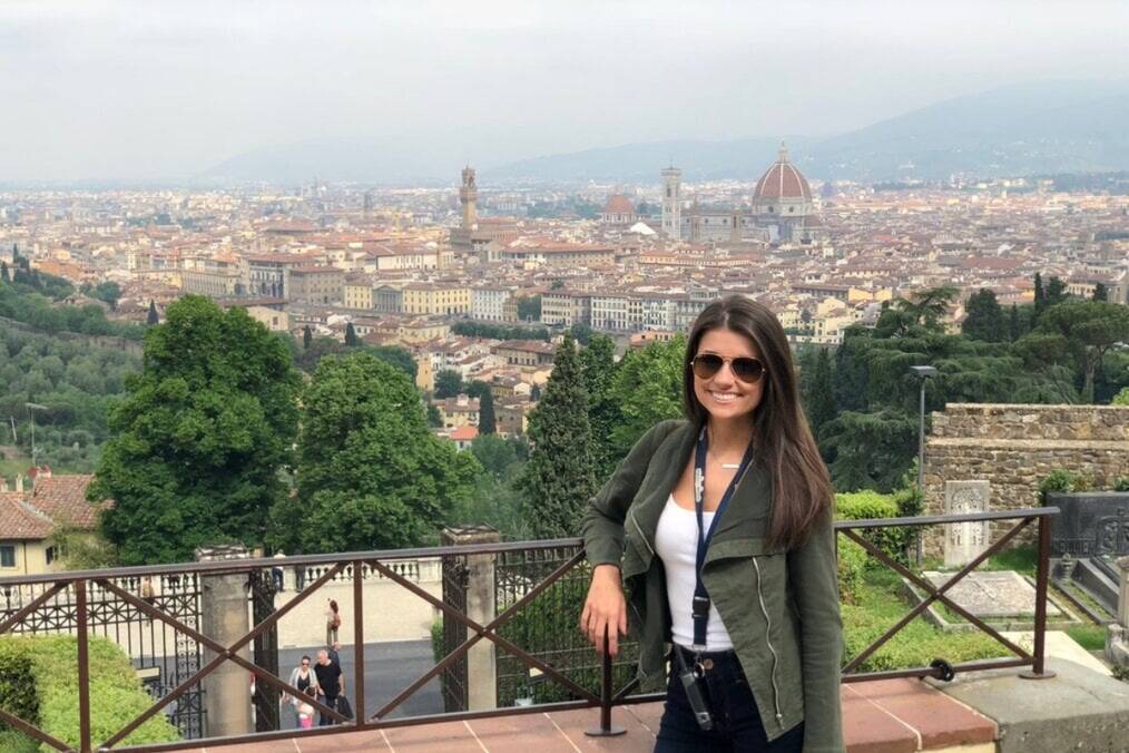 A person stood in front of a scenic view of an Italian city