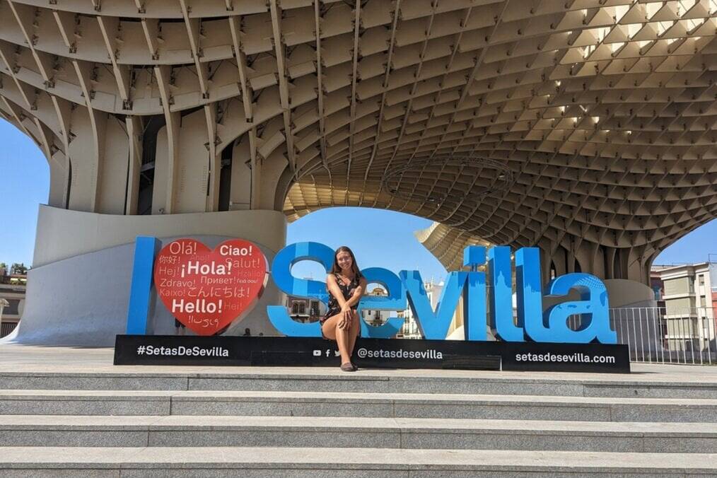 A person sat next to an I love Seville sign