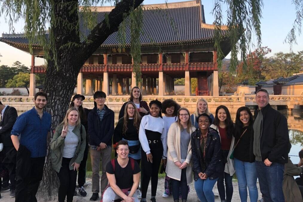A group of people standing near a historic Korean temple