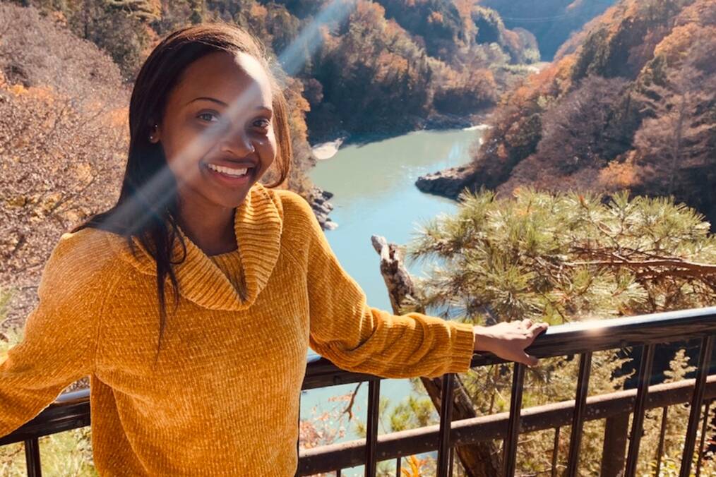 A person standing in front of a scenic river view